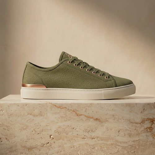 ERTH CLASX olive canvas sneaker right facing on a stone platform with a beige background